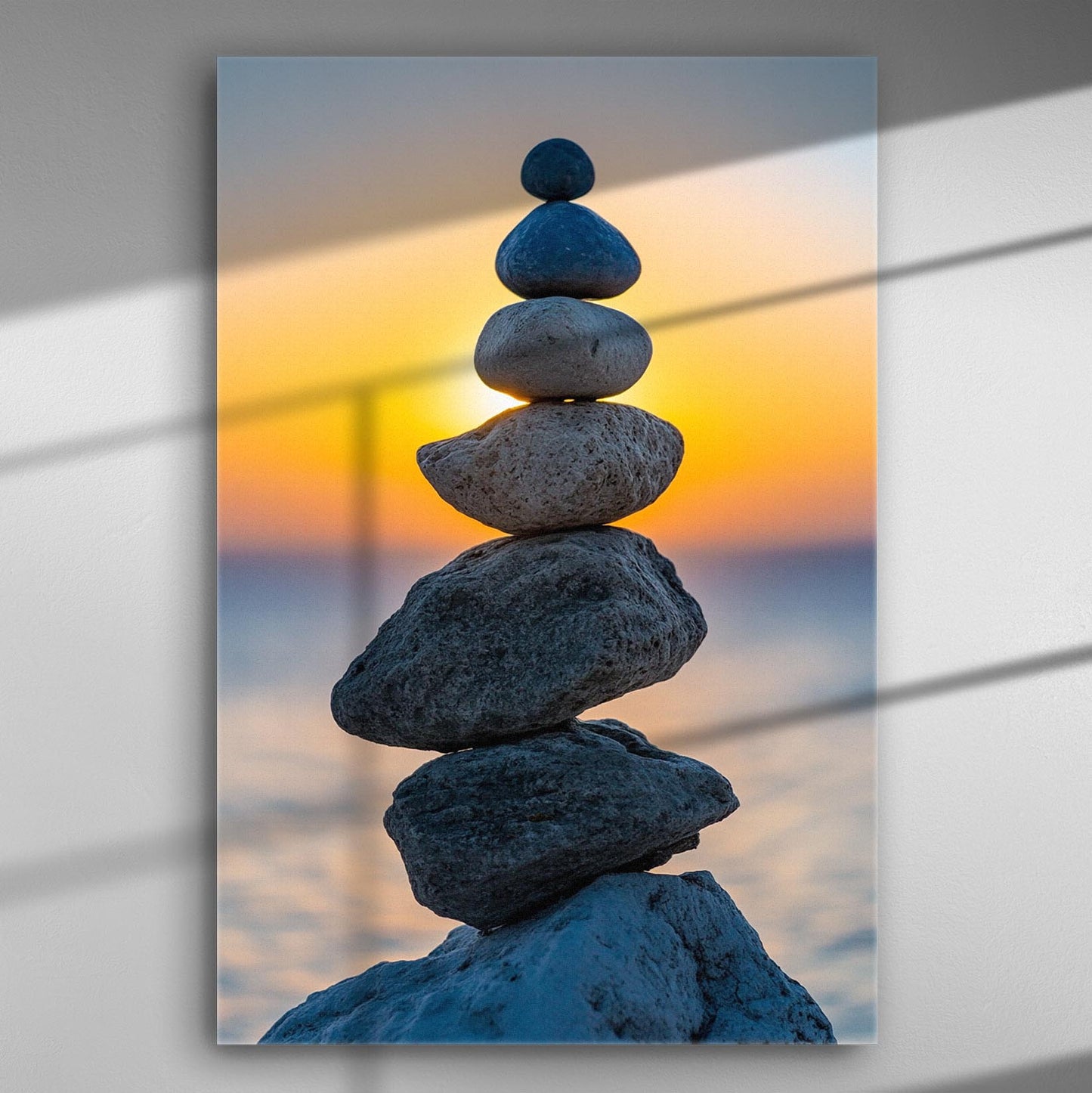 Stacked stones against a sunset background, creating a tranquil and harmonious scene.