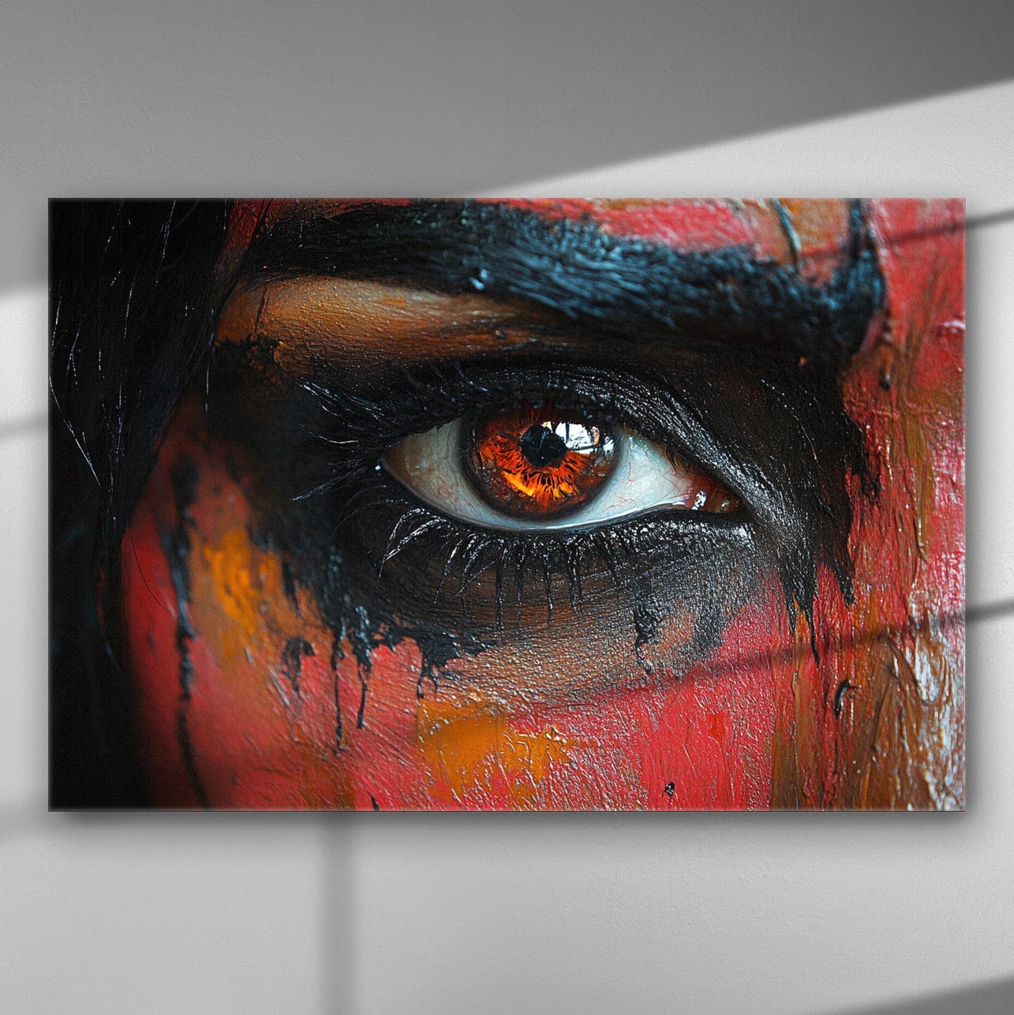 A close-up of a painted eye with vibrant orange and black colors on canvas