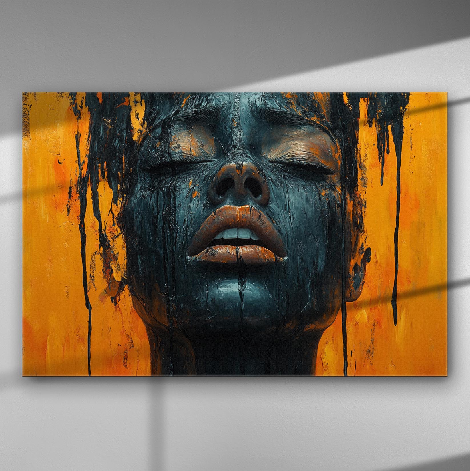 A canvas print of a face with black paint on an orange background, showcasing emotional expression and artistic contrast.