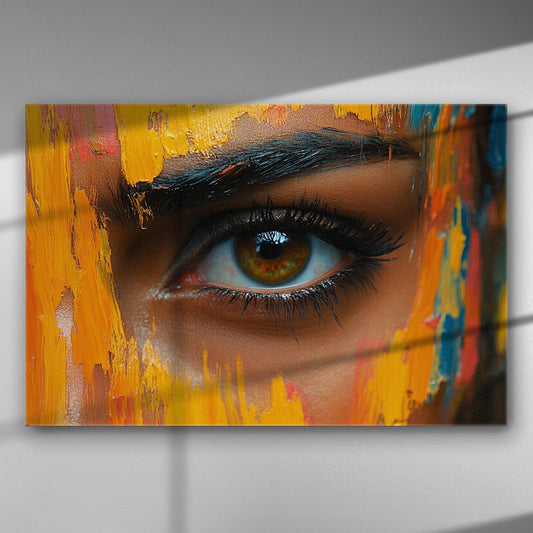 Close-up of an eye surrounded by vibrant strokes of yellow, orange, and other colors on a canvas.