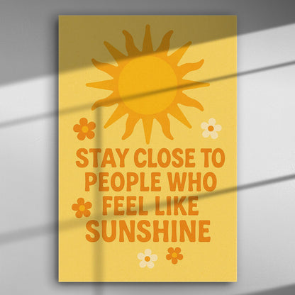 Canvas print with the phrase 'Stay Close to People Who Feel Like Sunshine' with a sun and flowers on a yellow background.