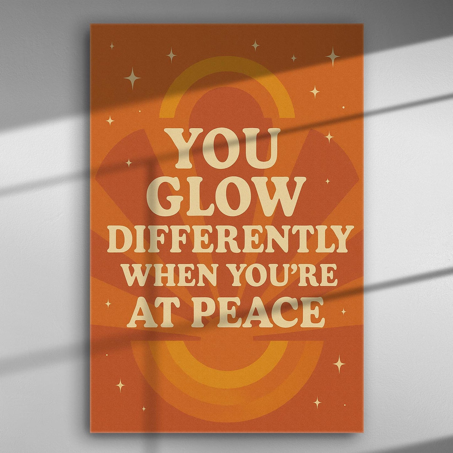 Canvas print with quote 'You glow differently when you're at peace' in orange and beige tones.