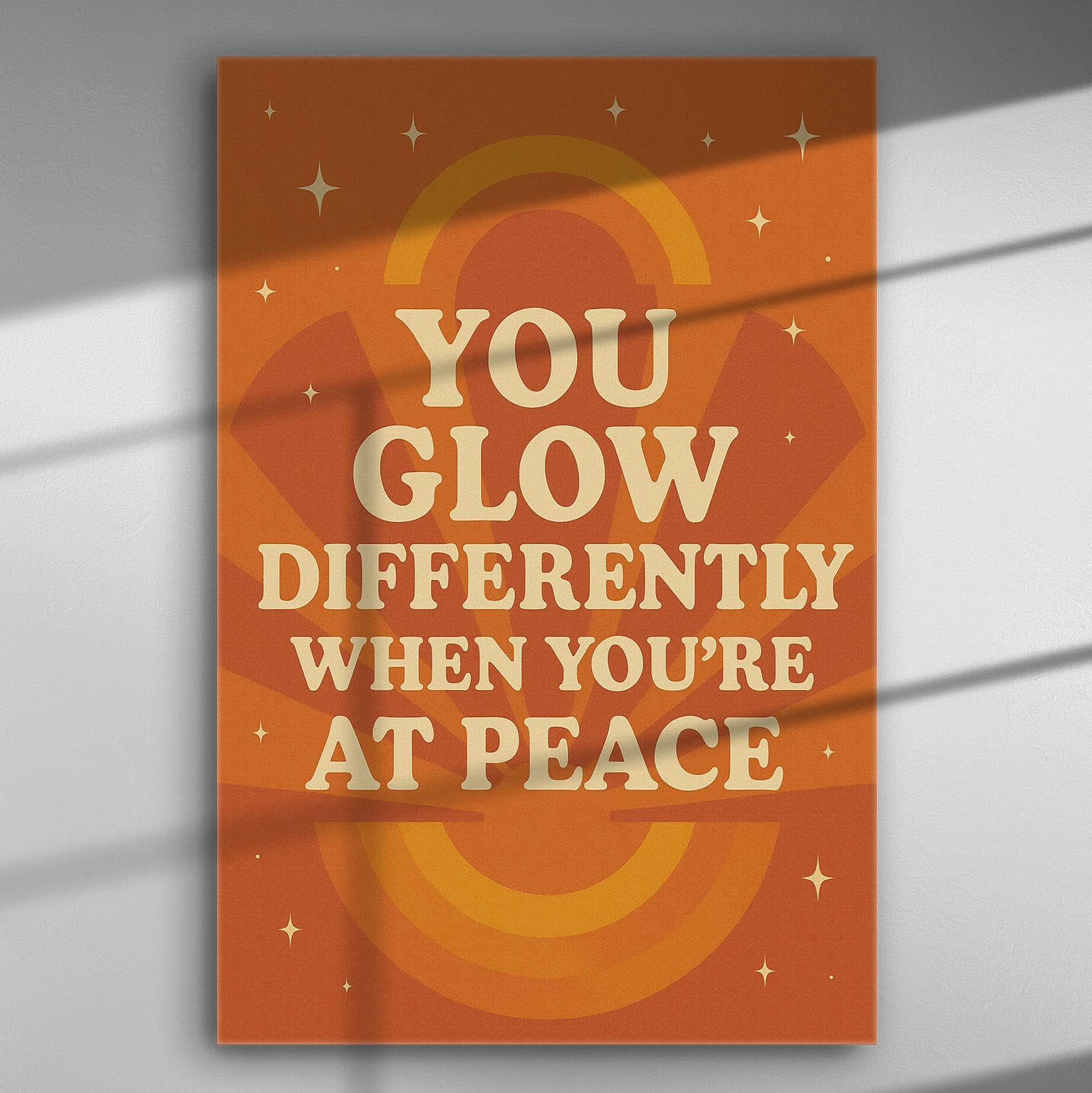 Canvas print with quote 'You glow differently when you're at peace' in orange and beige tones.