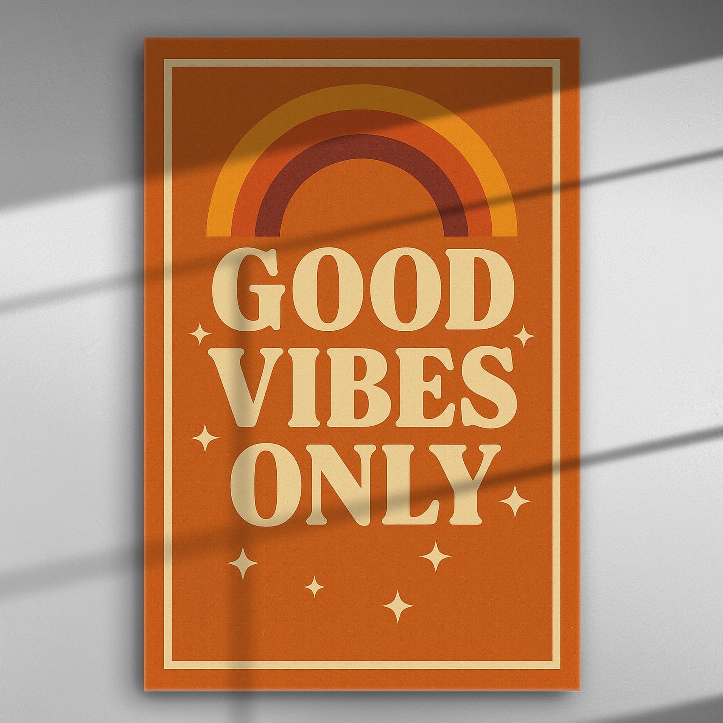 A canvas print with the text 'Good Vibes Only' and rainbow design in warm orange color.