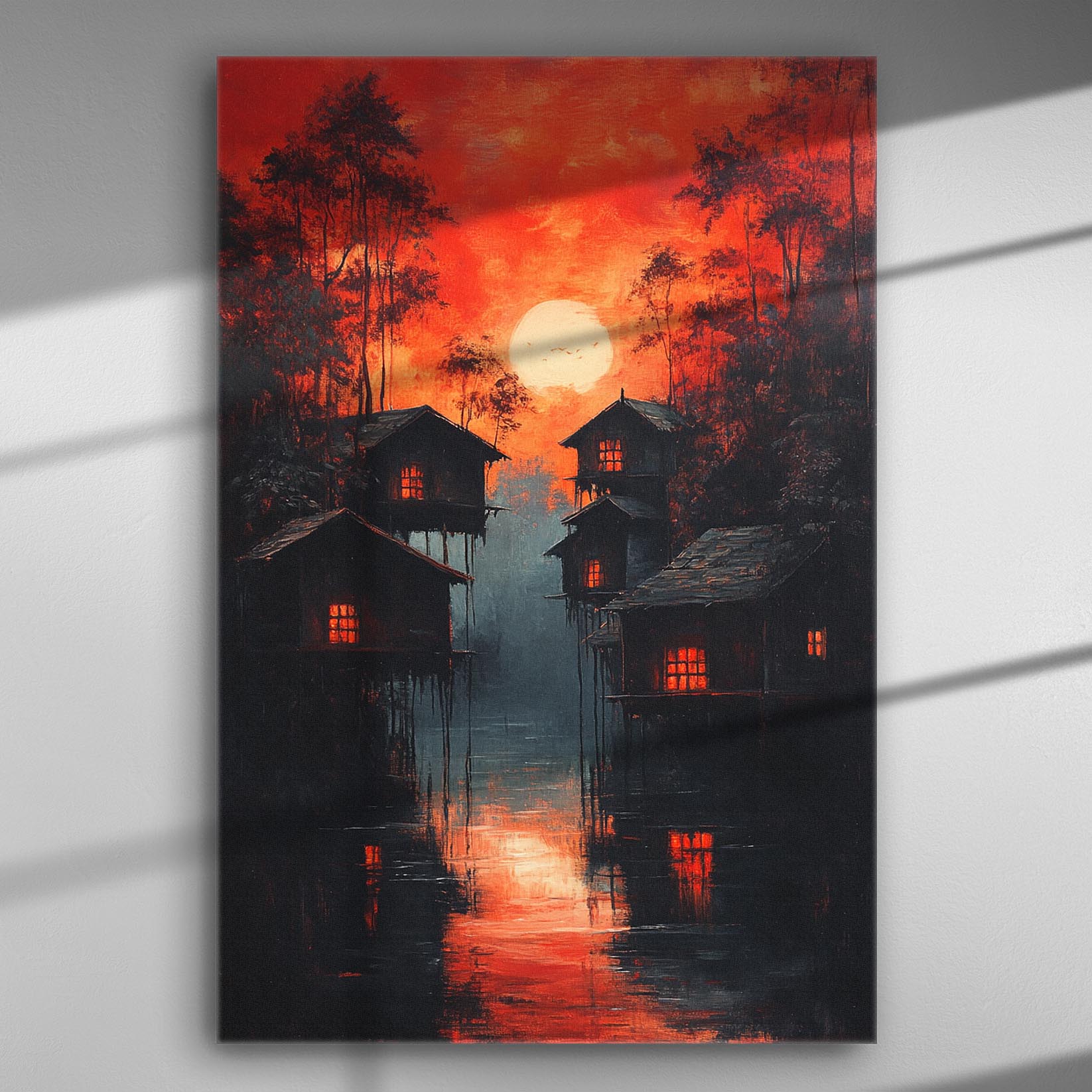 Canvas print depicting houses silhouetted against a vibrant orange sunset over a forest setting with reflections in calm water.