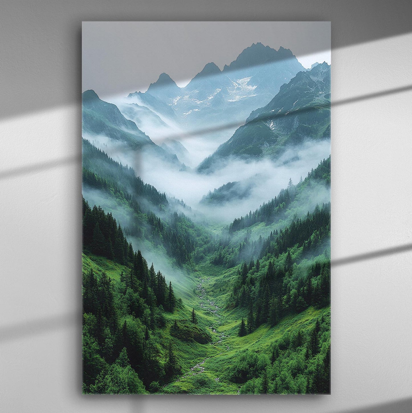 Mountain landscape with mist covering valleys and peaks, green forests below.