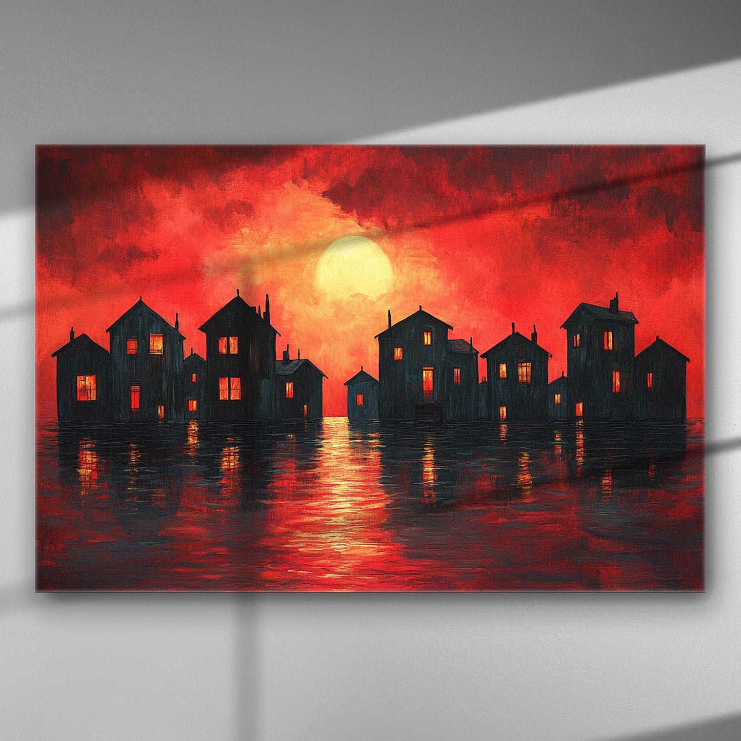 Sunset with silhouette of houses reflecting on water, vivid red and orange sky.