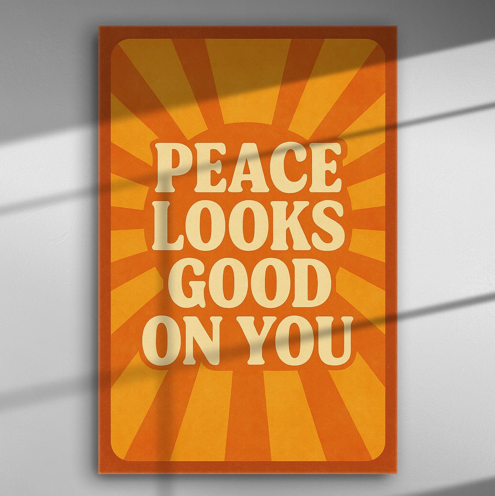 Canvas print with the message 'Peace Looks Good On You' on an orange sunburst background.