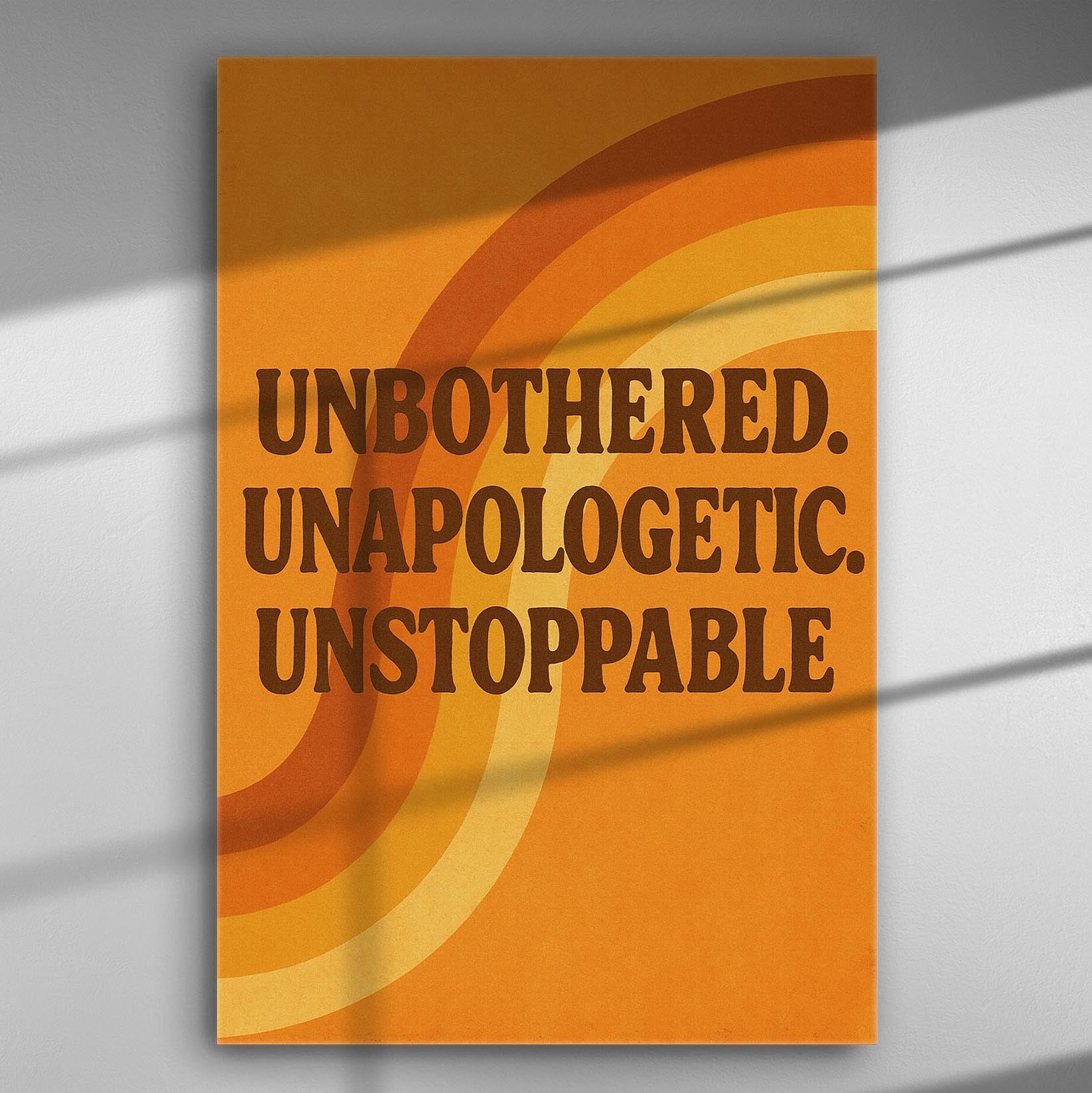 Canvas print with text 'Unbothered. Unapologetic. Unstoppable.' in orange and brown shades.