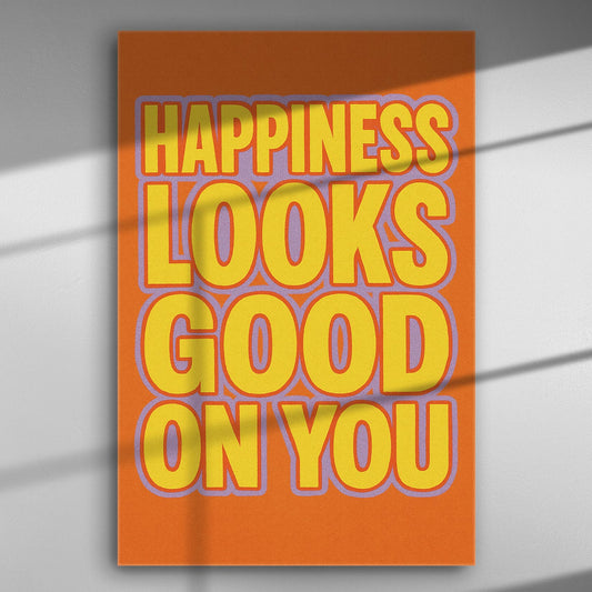 Canvas print with the text 'Happiness looks good on you' in bold yellow letters on an orange background.