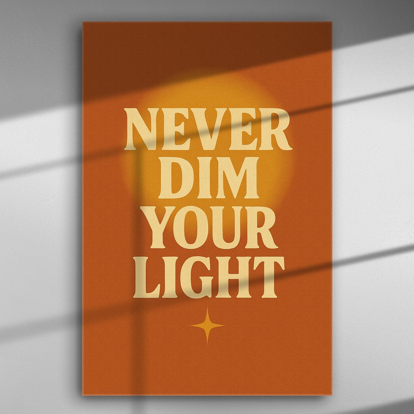 Inspirational canvas with the message 'Never Dim Your Light' on an orange background.