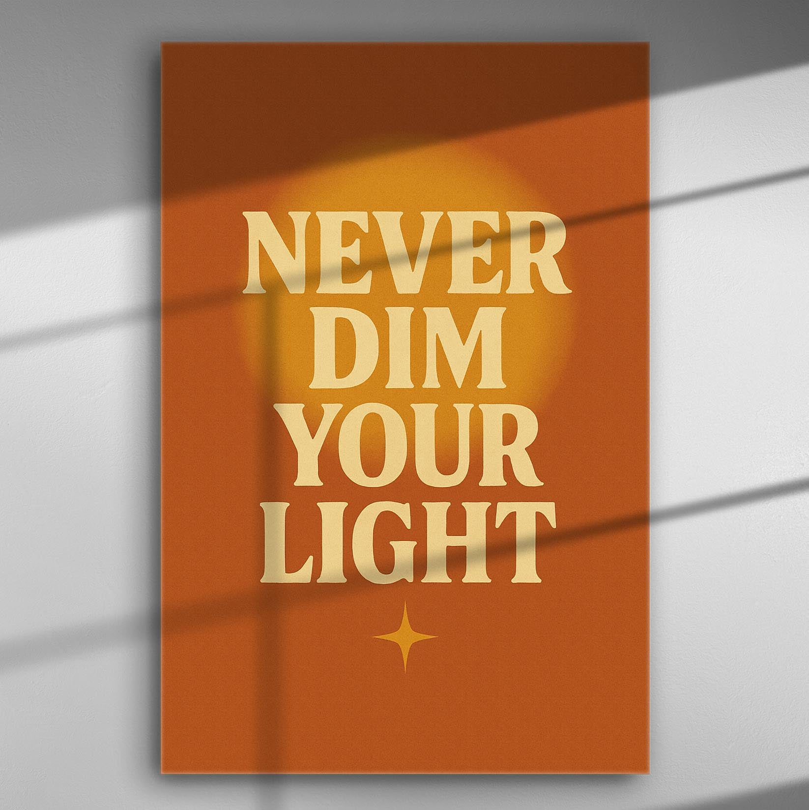Inspirational canvas with the message 'Never Dim Your Light' on an orange background.