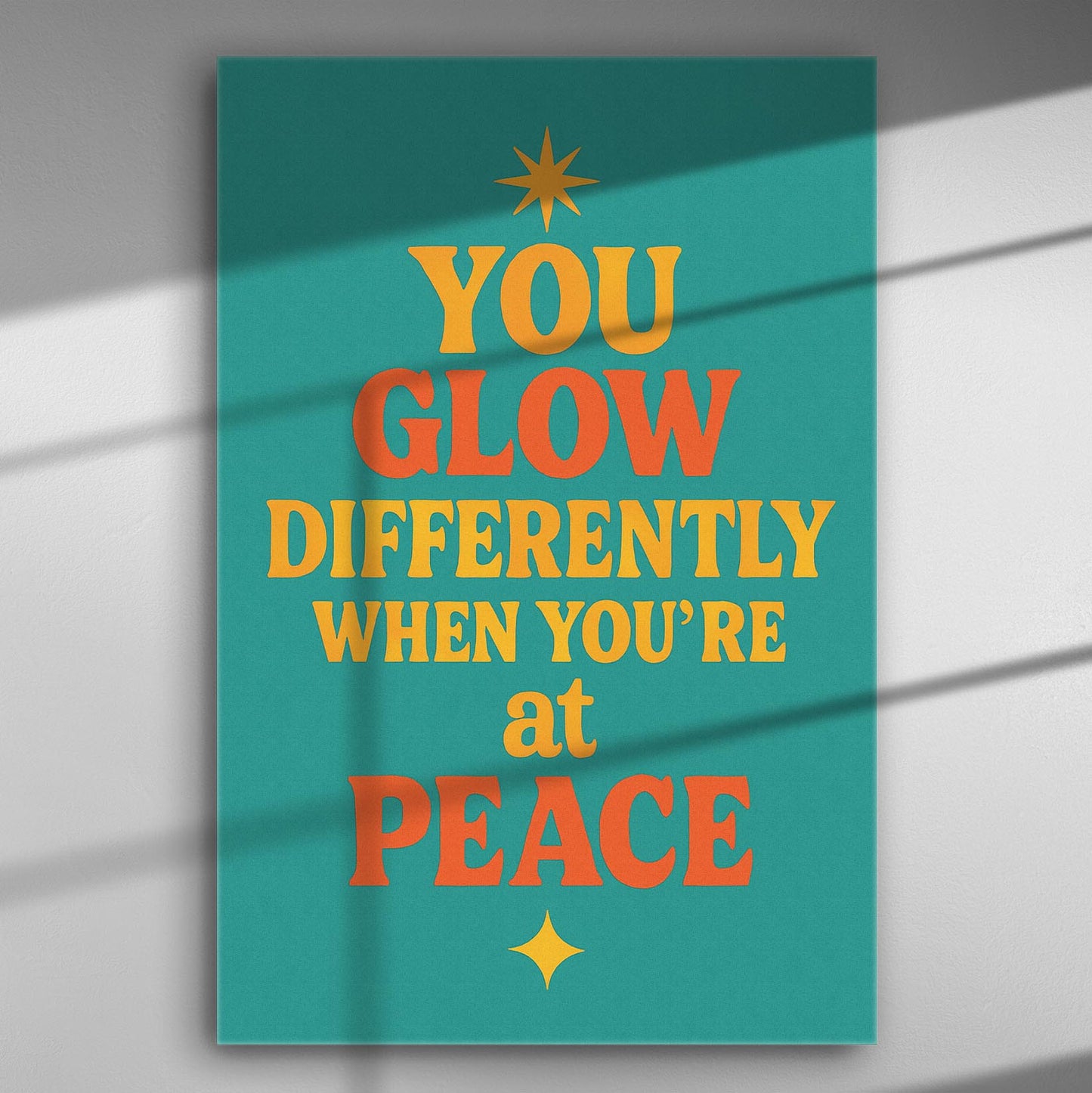 Canvas art print with the motivational quote 'You glow differently when you're at peace' in bold colors on a turquoise background.