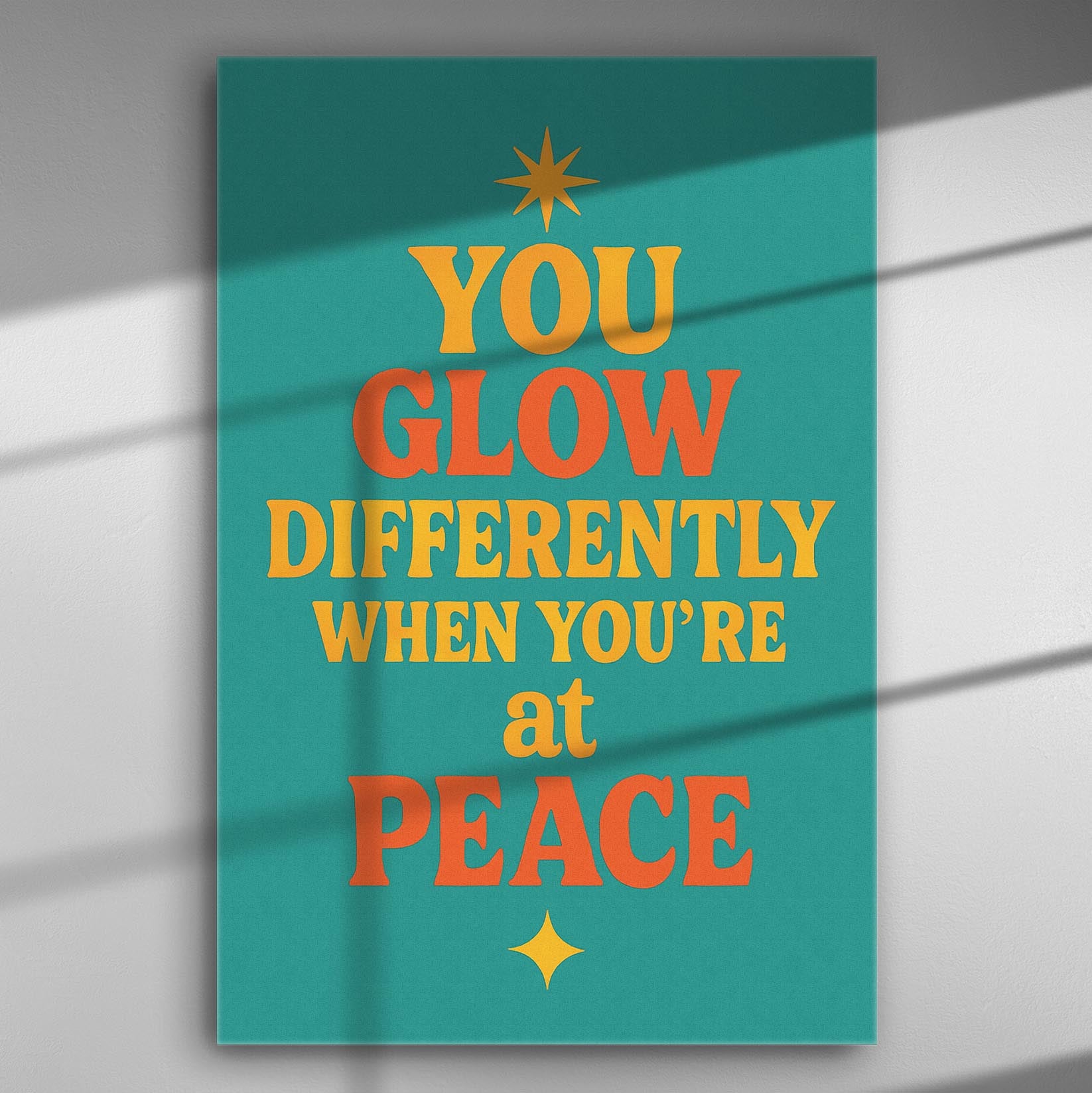 Canvas art print with the motivational quote 'You glow differently when you're at peace' in bold colors on a turquoise background.