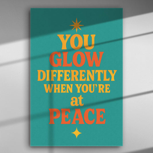 Canvas art print with the motivational quote 'You glow differently when you're at peace' in bold colors on a turquoise background.