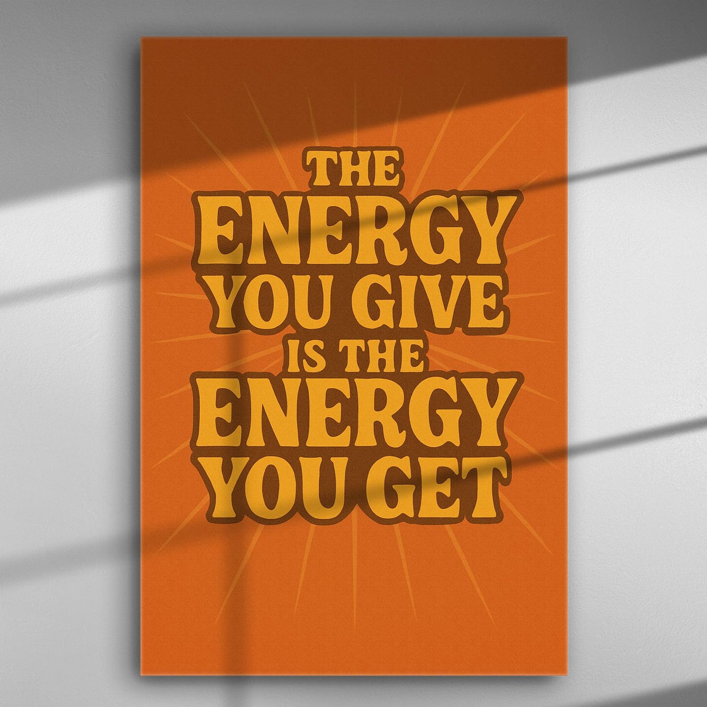 Canvas print with the quote 'The energy you give is the energy you get' on an orange background.