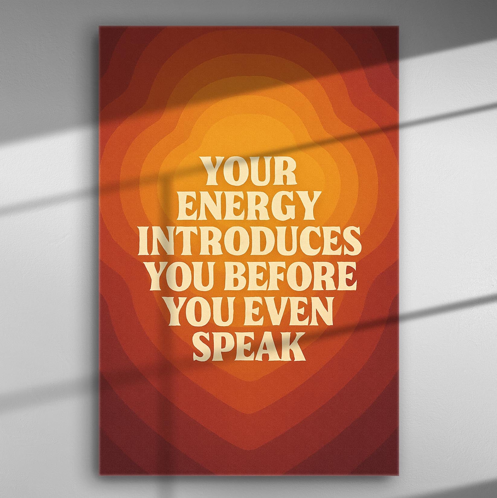Canvas print with the phrase 'Your energy introduces you before you even speak' in warm orange and red tones.