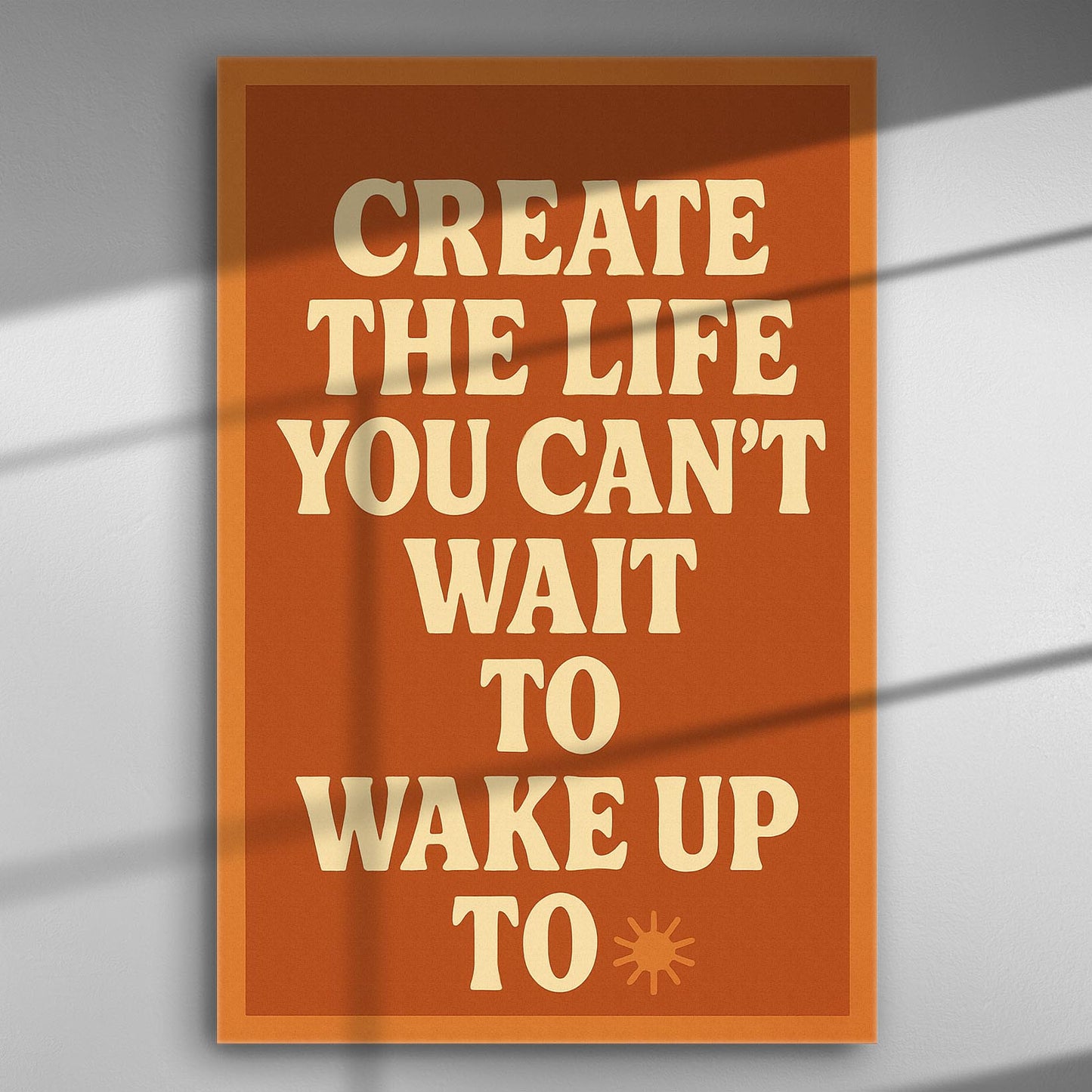 Canvas print with motivational quote 'Create the life you can't wait to wake up to' on an orange background.
