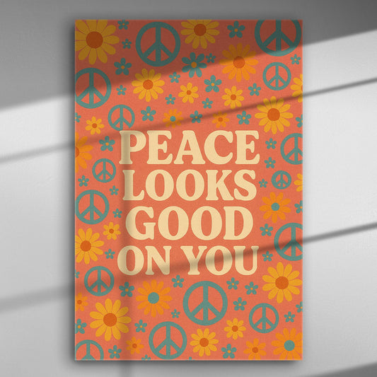 Canvas print with peace symbols and flowers on an orange background with the message 'Peace Looks Good On You'.