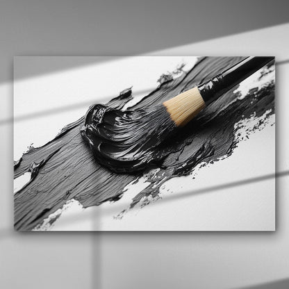 A close-up image of a paintbrush smearing black paint on a white surface.
