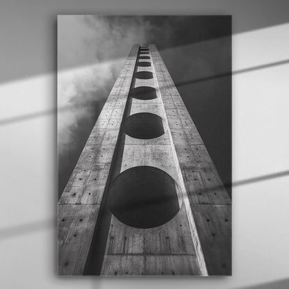 Black and white perspective photo of a skyscraper with geometric shapes looking upwards.