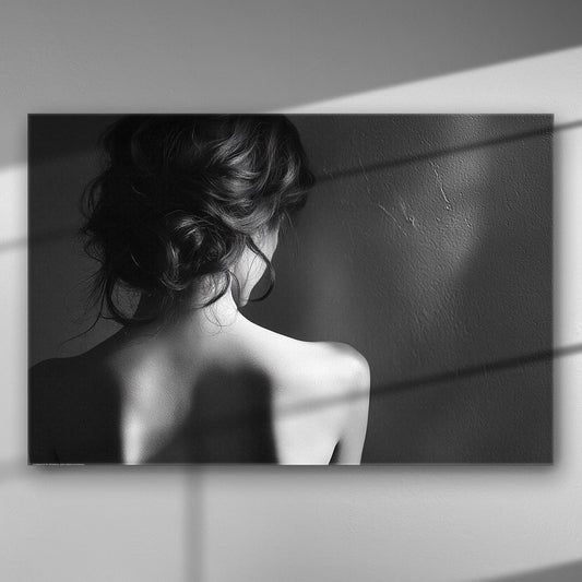 Black and white image of a woman's silhouette from the back with shadows on the wall.