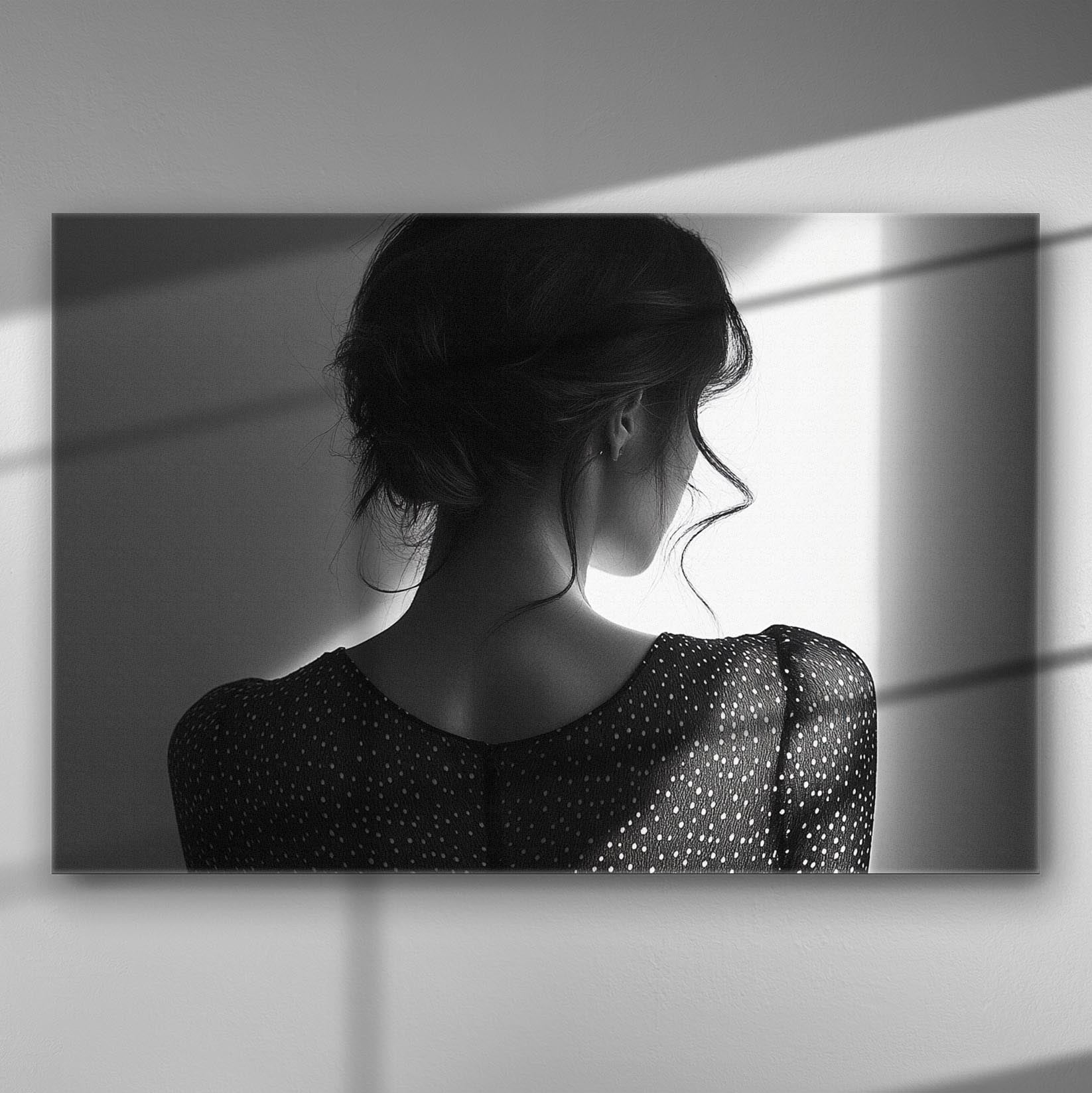 Black and white silhouette of a woman turned away, with dramatic shadow play on her back.