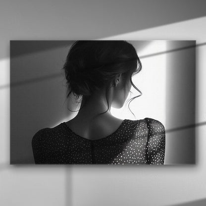 Black and white silhouette of a woman turned away, with dramatic shadow play on her back.