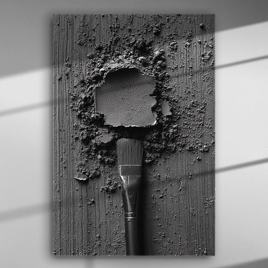 Black and white abstract artwork with a brush and textured surface on a canvas.