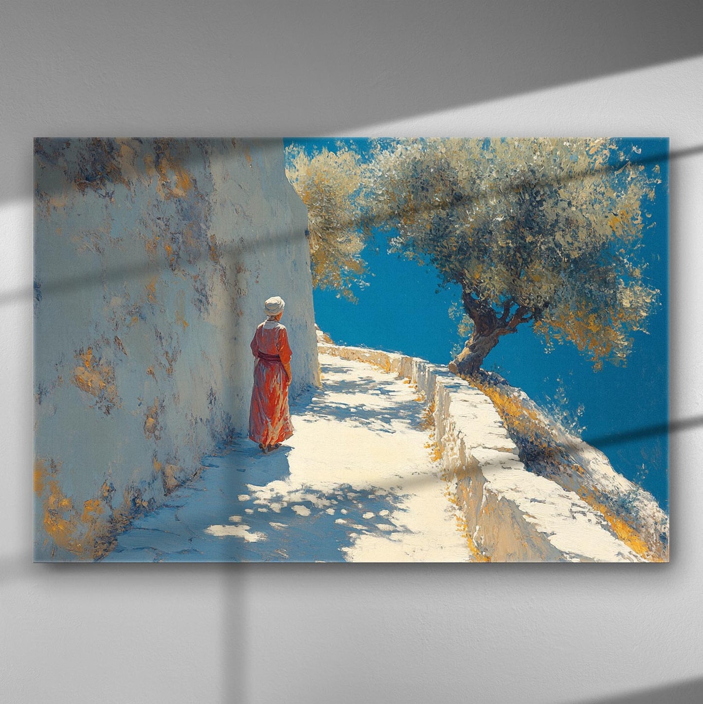 Canvas print of a solitary figure walking along a sunlit path with a blue sky and olive tree.
