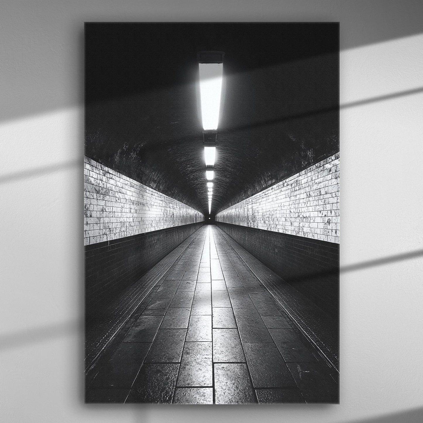 Black and white canvas print of a symmetrical tunnel with bright lights and tiled floor.