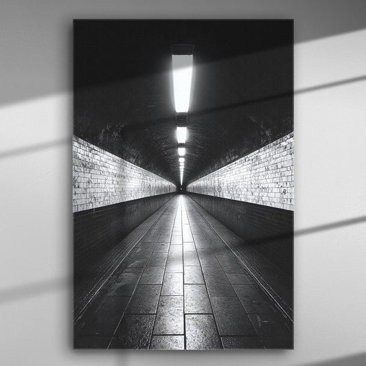 Black and white canvas print of a symmetrical tunnel with bright lights and tiled floor.