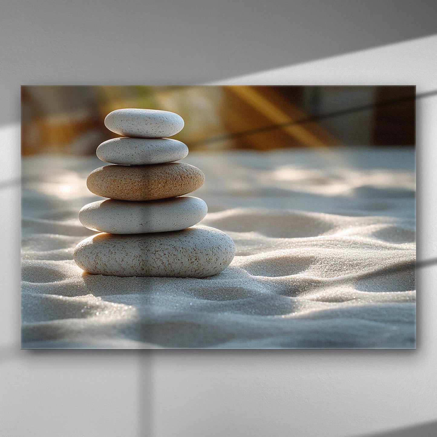 Canvas print of balanced stacked stones on sand with a serene atmosphere.